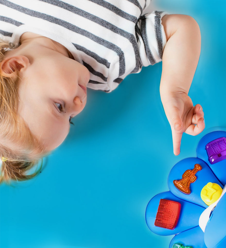 child pointing at baby toys