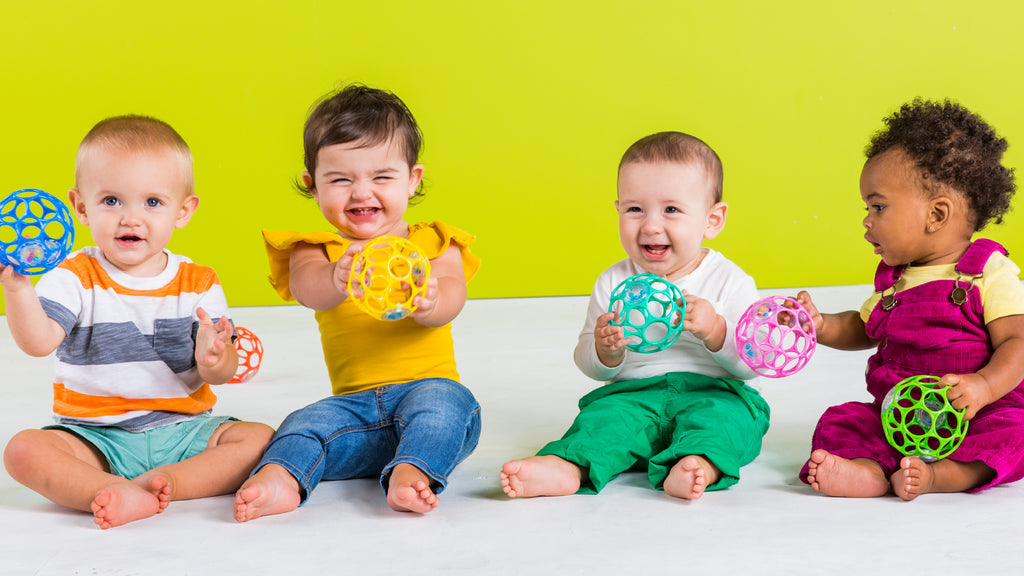 babies with toy balls laughing