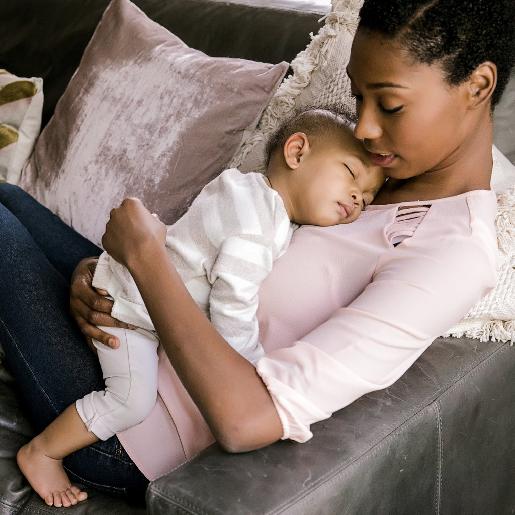 woman holding baby on a couch