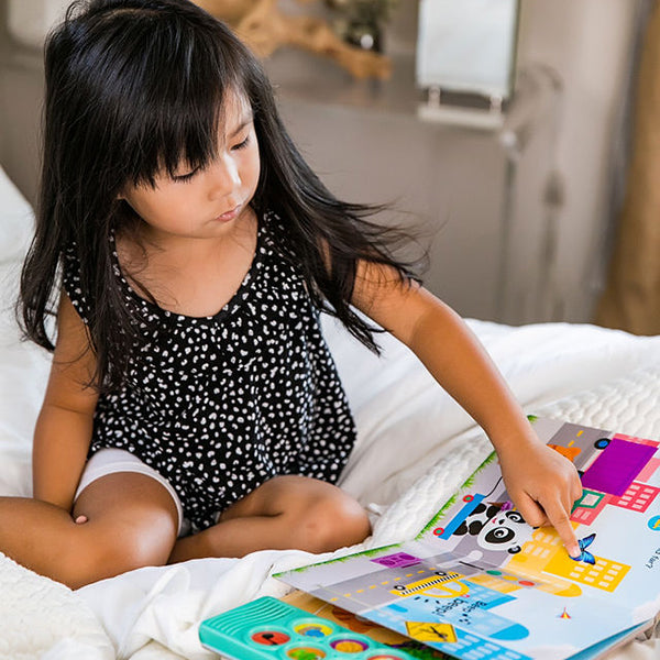 young girl reading on a bed