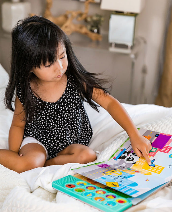 young girl reading on a bed