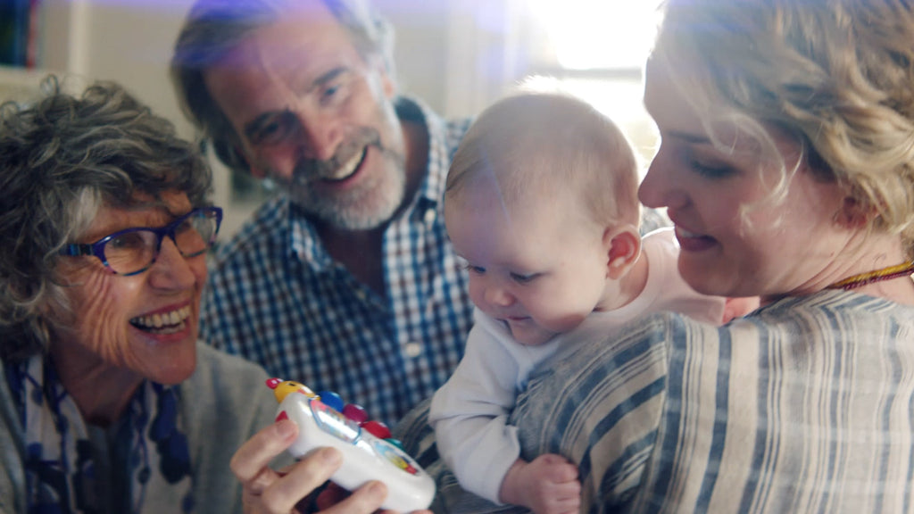 grandparents looking at a baby mom is holding