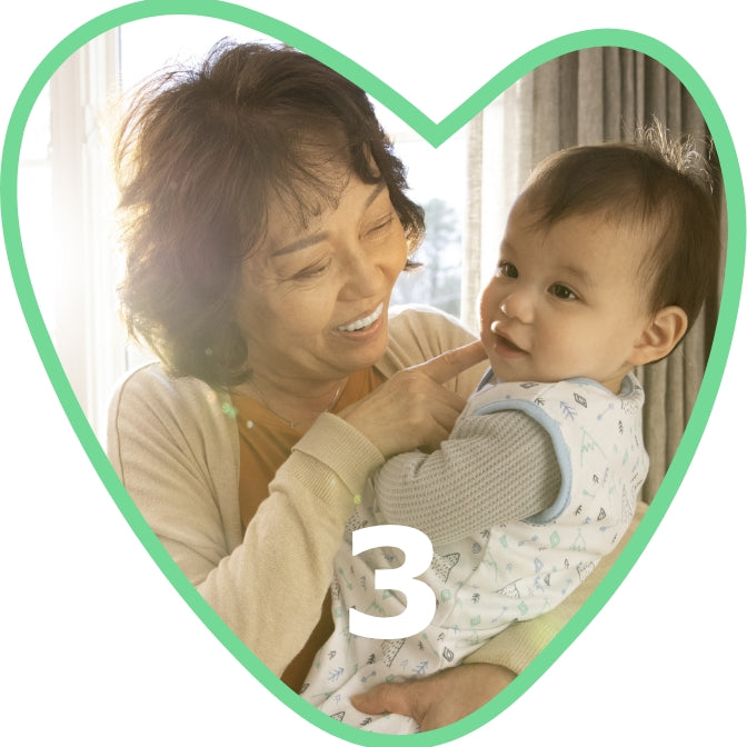 grandmother holding a baby in a swaddle